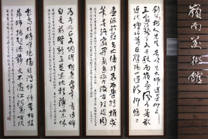 嶺南美術館門口，展示歐豪年教授創作書寫的四幅七言詩。攝影│張語辰