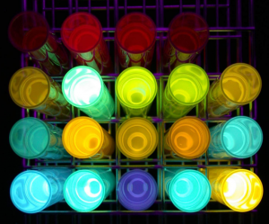 不同分子結構的 OLED 化合物溶液，在紫外燈的光激發下，各自發出耀眼的顏色。 圖片來源│陳錦地提供