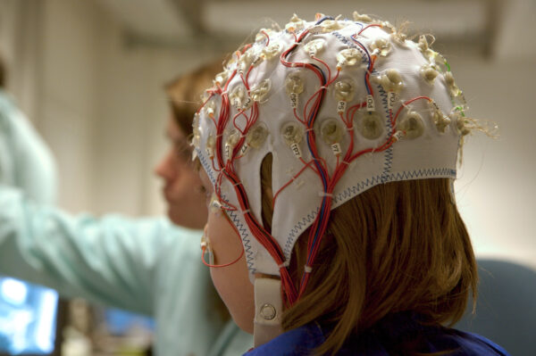 量測腦電波時，受試者需要戴上多個電極的帽子，以非侵入的方式量測頭皮電位。圖│iStock