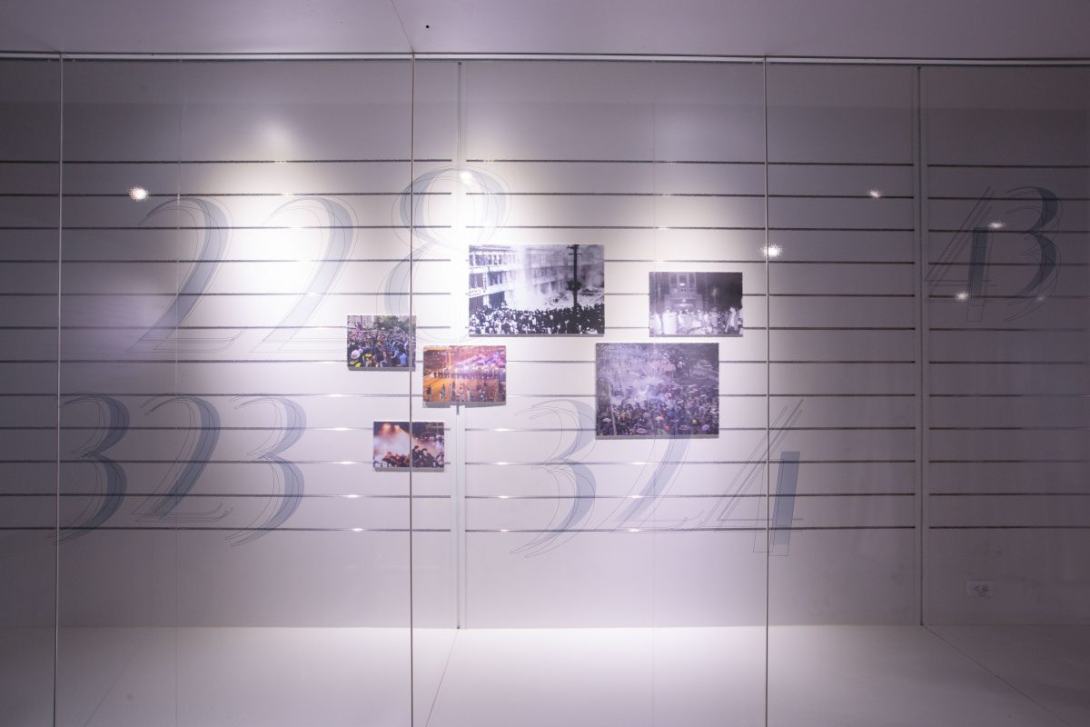 第一展區「傷痕密碼」，透過布滿數字密碼的玻璃櫥窗與歷史照片，回顧 11 場國內外著名的社會運動。 圖｜研之有物