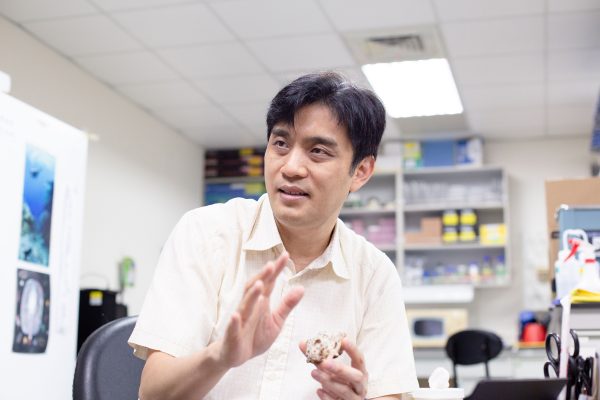 陳國勤正在和研之有物團隊介紹手上的藤壺樣本。 圖｜研之有物