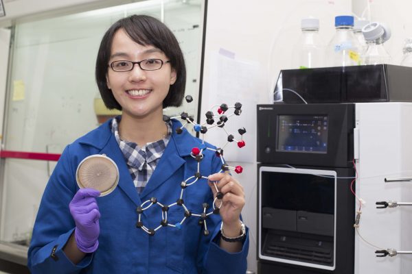 Holding a fungal culture and a LEGO-like model of okaramine, Dr. Hsiao-Ching Lin showcases the tools unlocking the secrets of natural insecticide production by fungi. Photo│Chang Yu-Chen